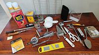 Photo showing entire lot of miscellaneous vintage kitchen tools and accessories spread on table.