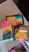 Photo showing assorted sticky notes in various colors and shapes including star-shaped and rectangular sticky tabs