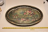 Full top view of the oval decorative tray showing floral artwork and gold highlights.