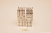 Photo showing two unopened Burberry product boxes featuring the brand's plaid pattern and labels.