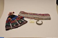 Photo of the entire lot with tribal hat, decorative belt, and metal bracelet on a flat surface against a neutral background.