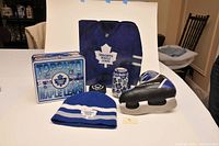 Photo showing all lot items including lunchbox, binder, knit hat, ceramic skate bank, stuffed skate