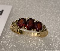 Top view showing three oval garnets and two diamonds set in 14k yellow gold