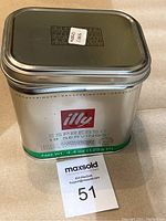 Metal illy Espresso coffee tin container with sticker label 'World Coins' indicating the lot contents.