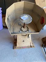 Side view of the jewelry lapping machine showing the hexagonal vented hood and rotating circular plate inside.