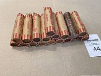 Photo of 18 rolls of Canadian one cent coins wrapped in paper labeled '50 pennies 50¢ Canadian'.