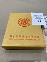 Gold-colored box with red text '2003 Lunar Year of the Goat Proof Silver Coin' and Central Trust of China logo