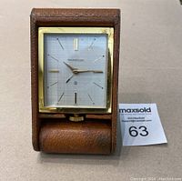 Front view of clock dial and folding leather case