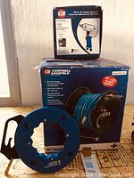 Photo of box sets for Campbell Hausfeld 50' hose reel and 1/2" air impact wrench showing product images and feature descriptions.