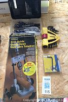 Overview of drill guide on box, Allen keys set, drill bits case, and blue hand tool in original packaging.