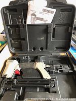 Porter-Cable 18 gauge narrow crown staple gun displayed inside molded black plastic carrying case with instruction manual.