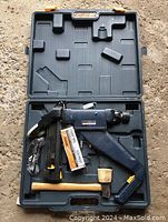 Mastercraft flooring nailer tool, wooden mallet, box of nails, and carrying case inside the open molded plastic case.