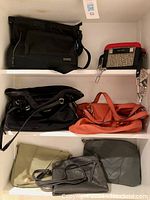 Photo of six purses including black laptop bag, orange and green purses, and two darker smaller purses on shelves.