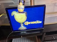 Front view of illuminated CoronaRita beer advertisement sign showing the margarita glass with inverted Corona bottle and lime wedge on blue background with yellow CoronaRita text.