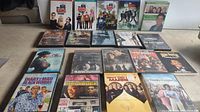 Front view of array of DVD cases showing Big Bang Theory seasons 1-4, Everybody Loves Raymond, Diary of a Mad Black Woman, and other movie titles.