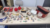 Full table view showing multiple vintage and collectible novelty items including watch, glasses, pins, truck, bread box and more