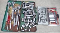 Full view of sockets, ratchets, extensions, and screwdriver handle in metal tray and plastic cases