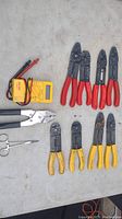 Overview of all tools on table: digital multimeter, crimpers, cutters, and scissors.