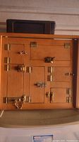 Front view of wooden lock display teaching board, showing multiple doors secured with brass and metal locks.