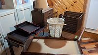 Photo showing various home office decor items including a floor lamp, wooden trays, a small drawer unit, a wire basket with fabric lining, and a woven basket.