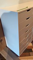 White IKEA storage chest with six drawers, angled side view showing drawer fronts and side panel.