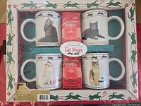Photo showing the full boxed set containing four cat mugs and two packets of gourmet ground coffee, with detailed cat pattern on packaging.