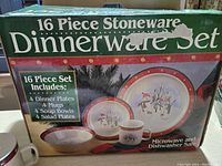 Photo of the boxed 16 piece stoneware dinnerware set showing contents and Christmas snowman design on plates and mugs.