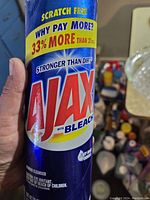 Close-up of Ajax Powder Cleanser with Bleach can showing brand and label details.