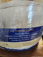 Close-up photo of comforter label showing details such as 260 thread count, 100% cotton cover, white down fill, king size
