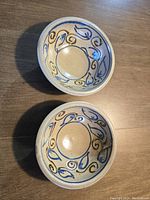 Photo of two ceramic bowls with blue and brown swirl design inside.