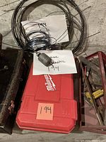 Overhead view of Milwaukee drill case with spools of wire and handwritten notes indicating "194 guide" and "supreme versamatic 194".