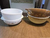 Overview of the Pyrex bowls, showing the different white and brown patterned bowls stacked.