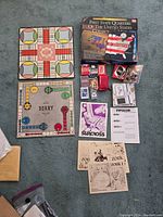 Photo showing collection of vintage board games including Sorry game board, UNO cards, First State Quarters collector map and albums, and classic computer game manuals and disks including Zork series and Starcross.