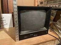 Vintage Rainbow 611 TV in black casing, front view showing screen and controls with a ruler for scale.
