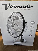 Box showing Vornado Silver Swan 3 Deco-Era Classic fan with brand, features such as durable metal construction, oscillation, three speed, and 5-year warranty.