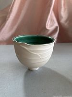 Side view of signed art pottery vase showing matte exterior and celadon interior