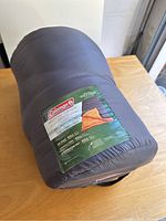 Photo showing Coleman branding and product label on gray carry sack for sleeping bag.