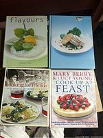 Four cookbooks arranged to show cover titles and food photography: Flavours by Donna Hay, Instant Entertaining by Donna Hay, Cooking for Friends by Williams Sonoma, Cook Up a Feast by Mary Berry & Lucy Young