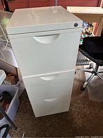 Front view of white IKEA filing cabinet with three drawers showing integrated handles and lock on top drawer.