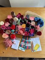 All latchhook yarn rolls arranged in tray with embroidery floss and kits on table