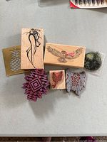 Photo showing eight wooden and metal stamps with nature-themed, geometric and insect designs on rubber.