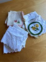 Close-up photo showing variety of napkins including embroidered and printed floral designs.