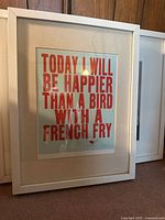Framed art print with red text 'Today I Will Be Happier Than a Bird with a French Fry' in a white IKEA frame.