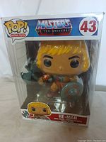 Front view of sealed Funko Pop He-Man figure in original packaging, showing figure and box artwork.