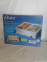 Image of Oster Buffet Warming Set box showing Spanish and English labels, condition new in box.