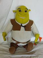 Front view of the vintage jumbo plush Shrek doll sitting upright with visible details of face, outfit, and attached movie tag.