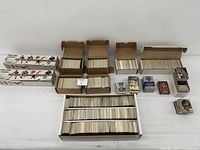 Overview of multiple card boxes, loose stacks and sealed sets on table