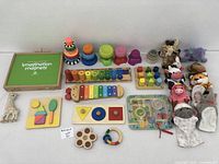 Overview photo of all educational toys, hand puppets, wooden stacking toys, xylophone, and imagination magnets box.