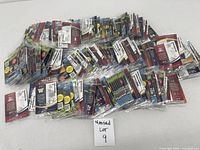 Wide view of multiple unopened football card packs arranged on white surface, showing team and player details through packaging.