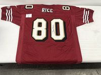 Back view of red 49ers #80 jersey showing 'RICE' nameplate and autograph on number 80